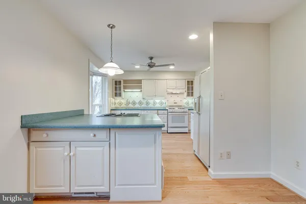a kitchen with granite countertop a sink cabinets and wooden floor