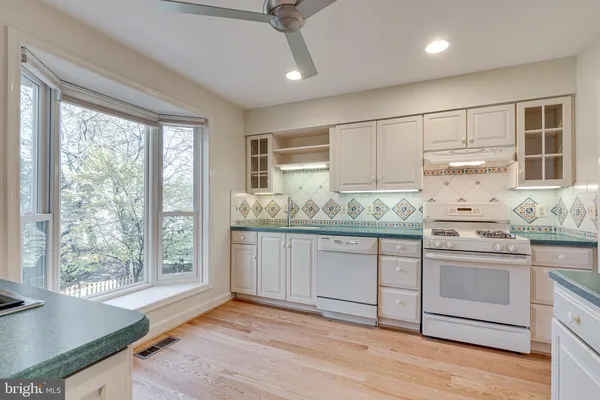 a kitchen with granite countertop white cabinets and white appliances