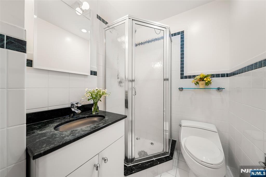 19 Central Avenue Demarest, NJ 07627 - Photo 24 of 49 a bathroom with a granite countertop sink a toilet and shower