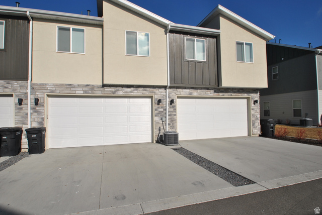 1219 West 1870 South Logan, UT 84321 - Photo 15 of 18 View of front facade featuring stone siding, a garage, concrete driveway, and stucco siding