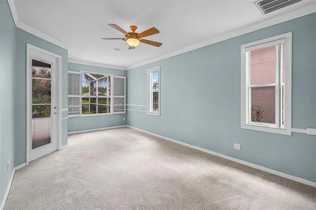 an empty room with windows and fan