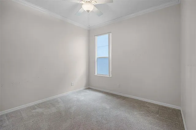 an empty room with a chandelier fan