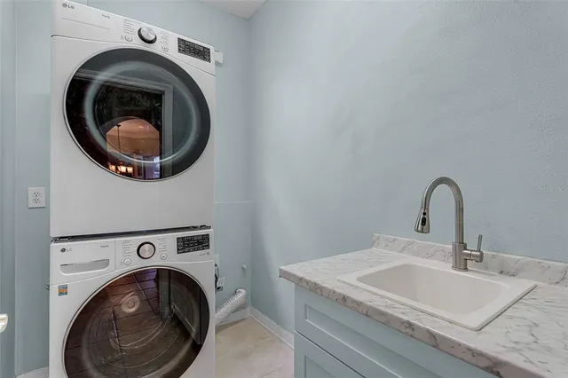 a utility room with sink dryer and washer