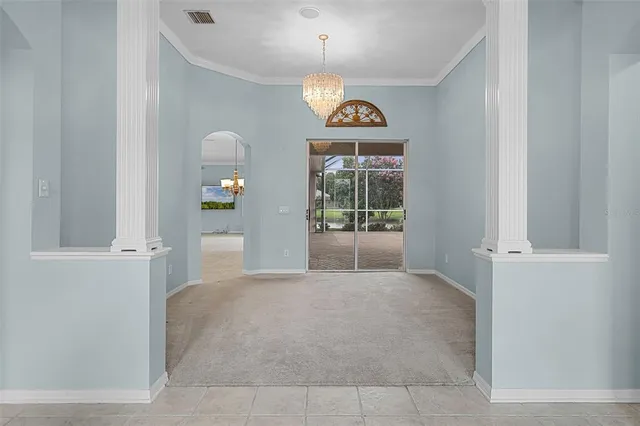 a view of a hallway with window and chandelier