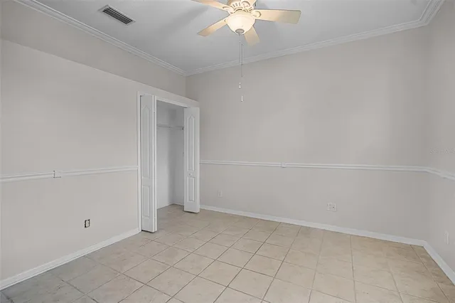 an empty room with a ceiling fan and carpet