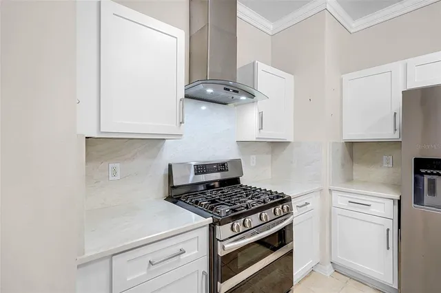 a kitchen with stainless steel appliances white cabinets and a stove