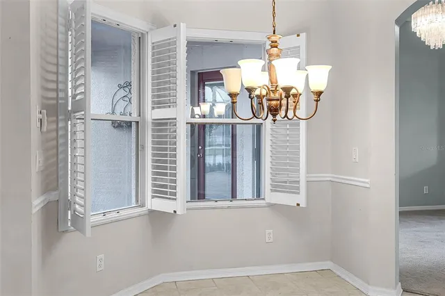 an empty room with chandelier fan