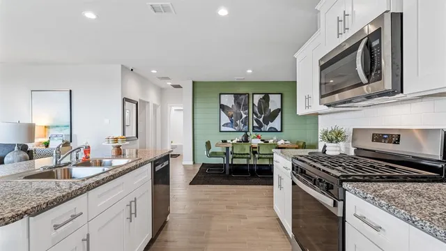 a kitchen with a granite countertop sink and a refrigerator