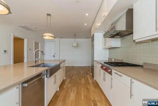 a kitchen with stainless steel appliances a sink stove and cabinets