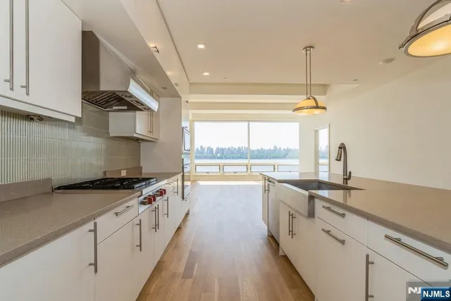 a kitchen with stainless steel appliances a sink stove and cabinets