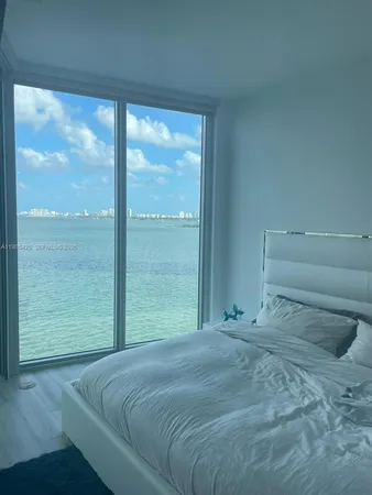a bedroom with a bed and a large window
