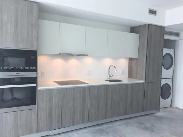 a kitchen with granite countertop a cabinets and a stove top oven