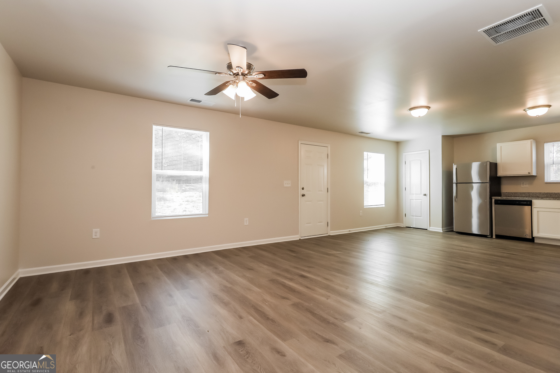 20 Sloane Court Covington, GA 30016 - Photo 5 of 16 a view of empty room with wooden floor and window