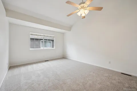 an empty room with windows and fan