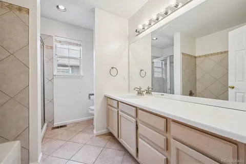 a spacious bathroom with a double vanity sink a mirror and a shower