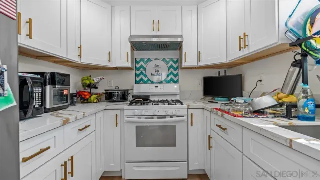a kitchen with stainless steel appliances white cabinets and a stove