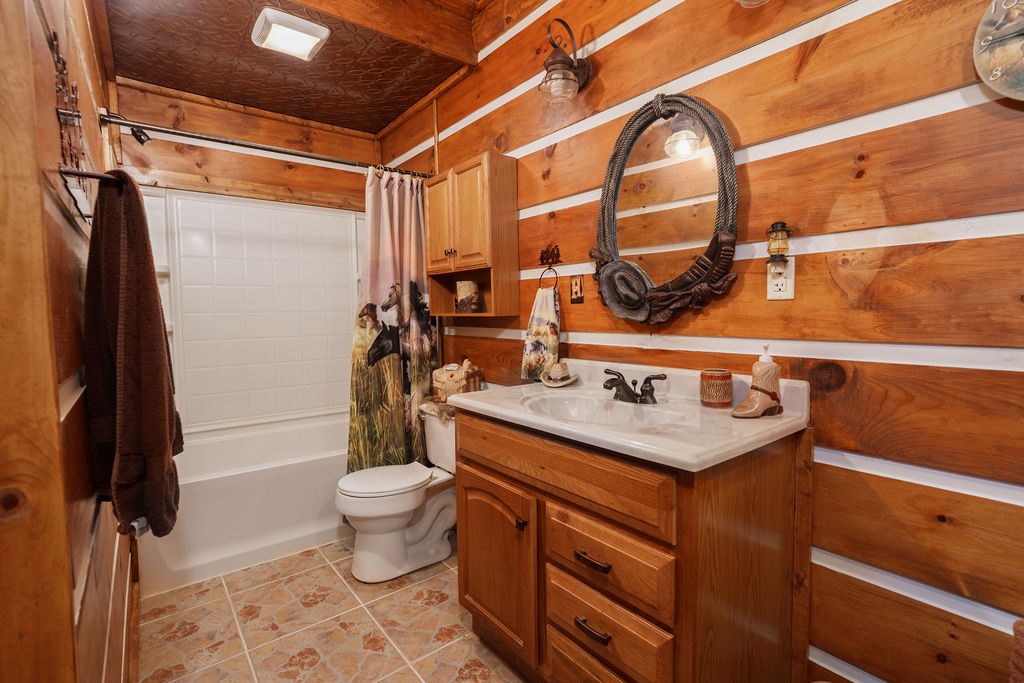 120 Foxfire Road Blue Ridge, GA 30513 - Photo 32 of 55 a bathroom with a granite countertop sink a toilet and a shower curtain