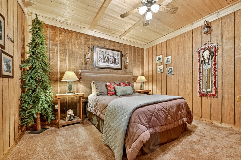 120 Foxfire Road Blue Ridge, GA 30513 - Photo 53 of 55 a bedroom with a bed and a chandelier