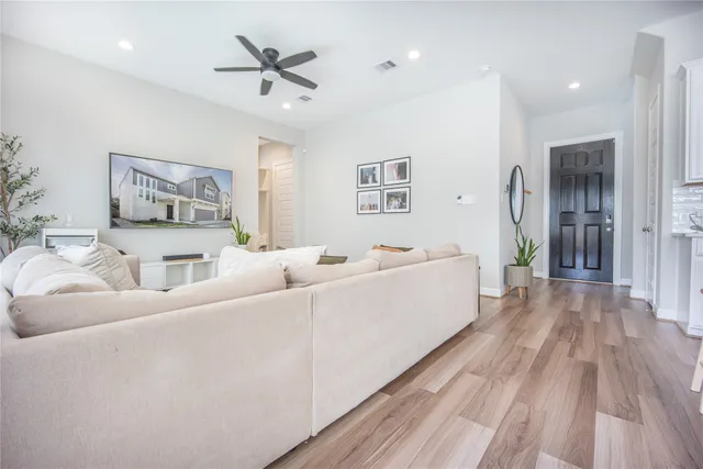 a living room with furniture and wooden floor