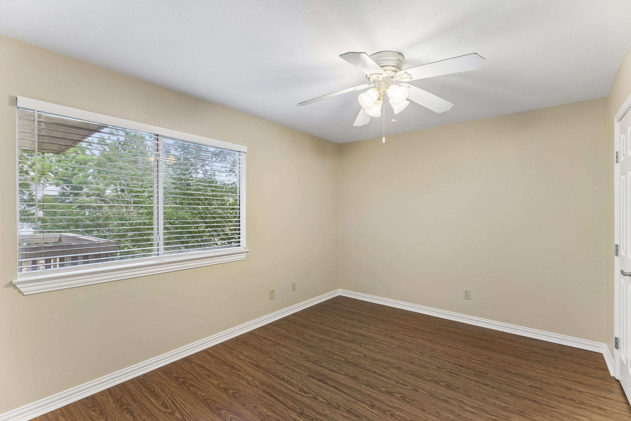 8340 Fathom Circle, Unit 103 Austin, TX 78750 - Photo 17 of 30 a view of an empty room with wooden floor and a window