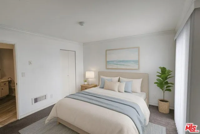 a bedroom with a bed and a potted plant