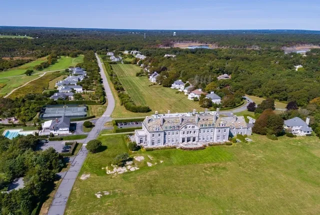 an aerial view of residential houses with outdoor space and trees