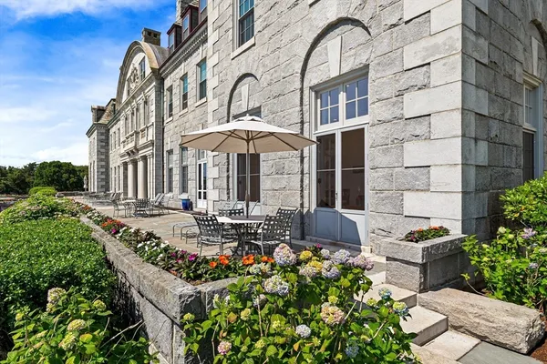 a front view of a house with swimming pool and furniture