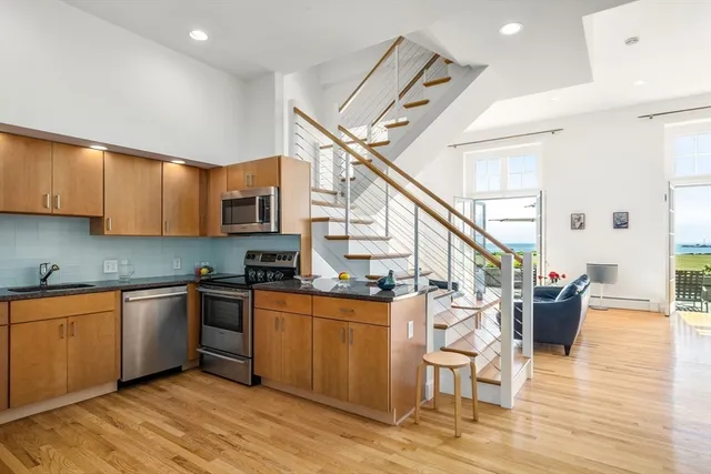 a open kitchen with stainless steel appliances granite countertop a stove and a wooden floors