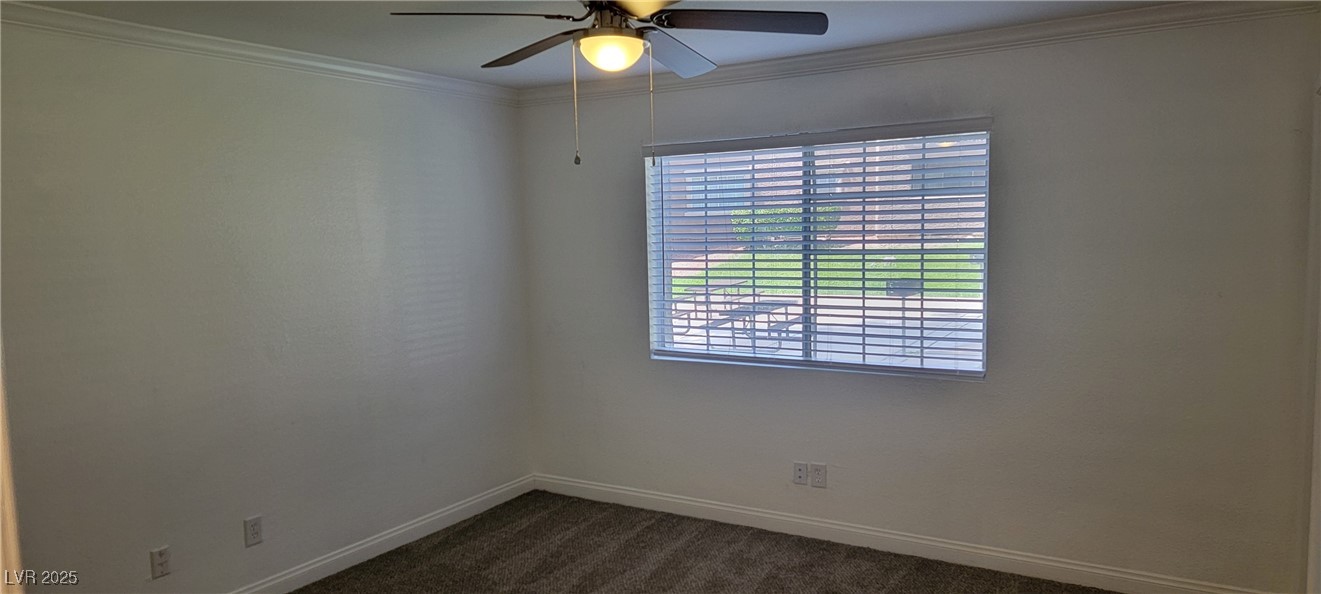 2750 South Durango Drive, Unit 1072 Las Vegas, NV 89117 - Photo 14 of 23 Empty room featuring dark carpet, crown molding, a