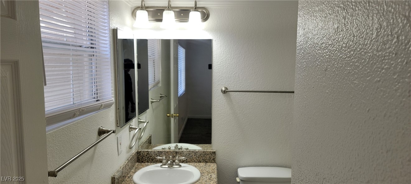 2750 South Durango Drive, Unit 1072 Las Vegas, NV 89117 - Photo 17 of 23 Bathroom featuring a textured wall and vanity