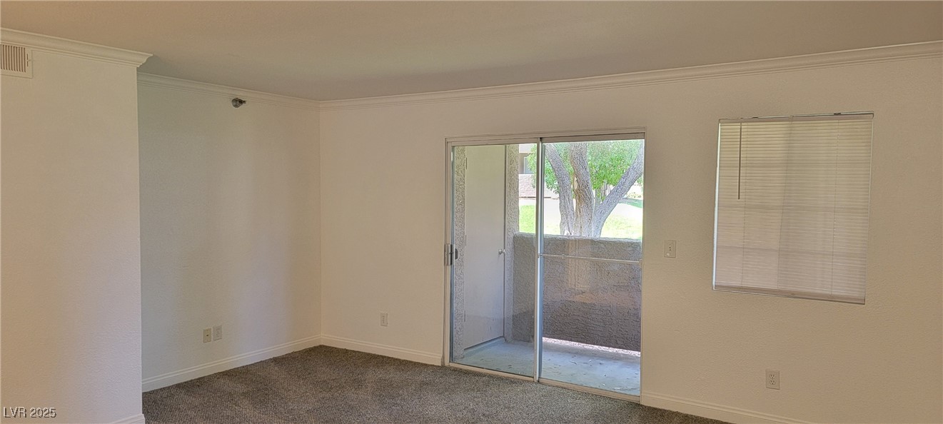 2750 South Durango Drive, Unit 1072 Las Vegas, NV 89117 - Photo 3 of 23 Empty room with crown molding and dark carpet