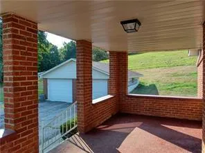 a view of a porch with wooden floor and a yard
