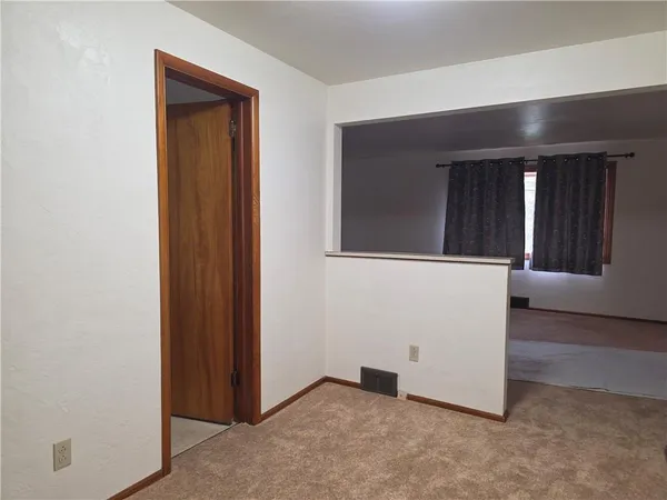 an entryway with wooden floor and cabinet