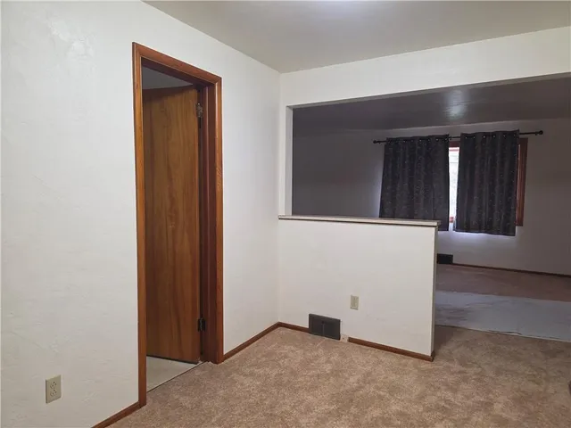 an entryway with wooden floor and cabinet