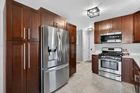 a metallic refrigerator freezer sitting in a kitchen