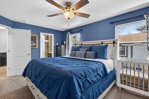 a bedroom with a large bed and ceiling fan