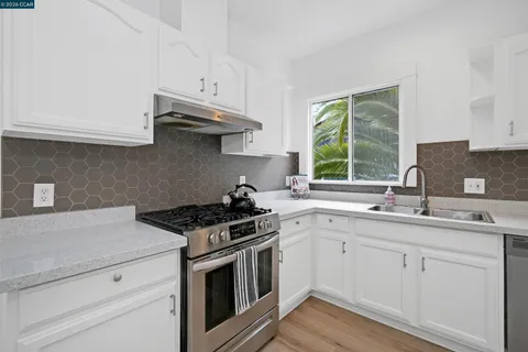 a kitchen with stainless steel appliances granite countertop a sink stove and cabinets