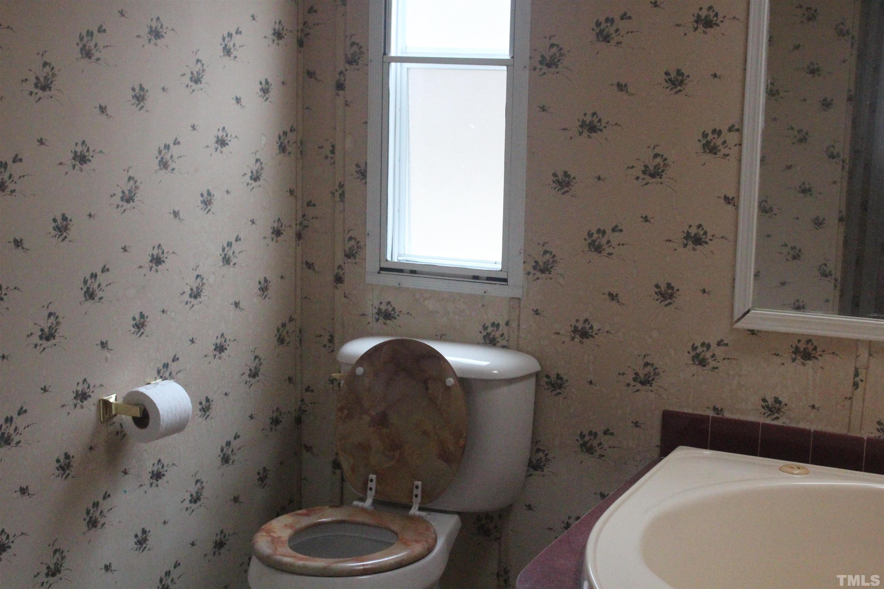 2986 Thomas Road Henderson, NC 27537 - Photo 13 of 21 a bathroom with a sink a toilet and a mirror