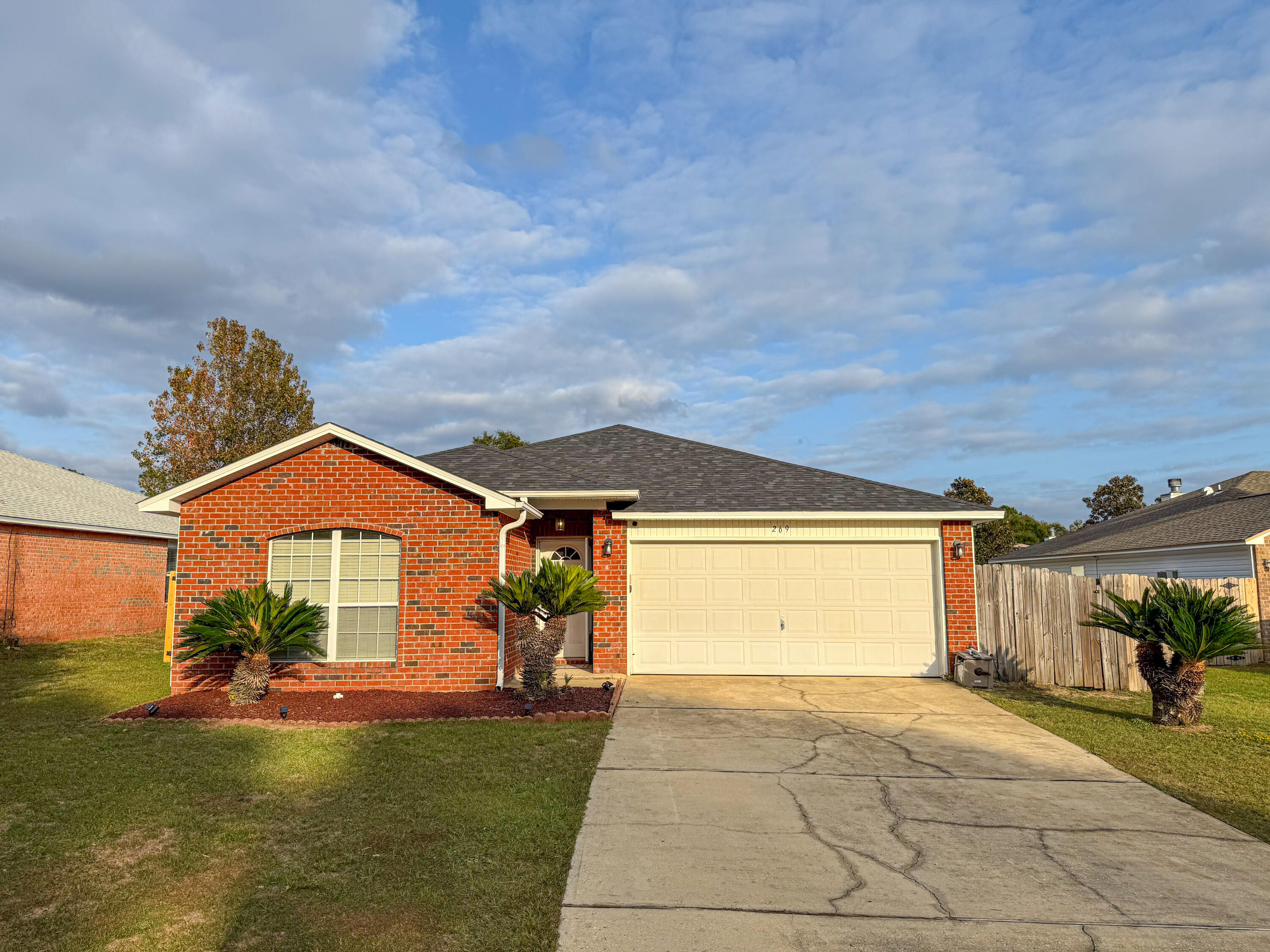 a front view of a house with a garden and yard