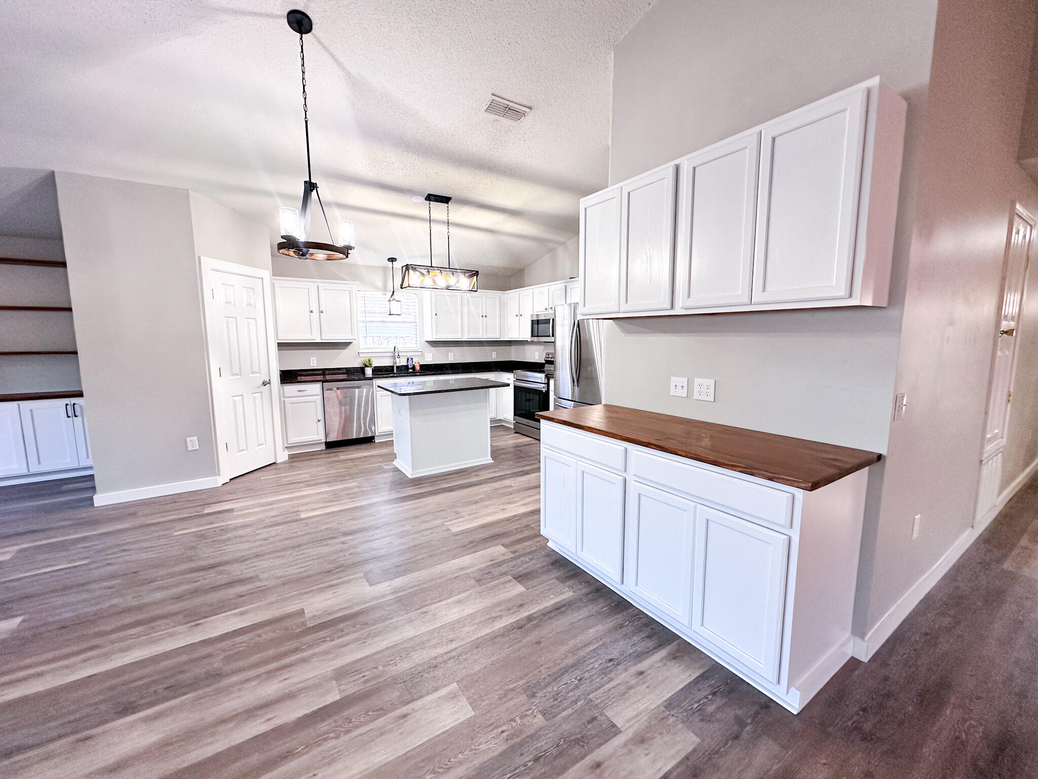 269 Limestone Circle Crestview, FL 32539 - Photo 11 of 32 a kitchen with stainless steel appliances white cabinets and wooden floor