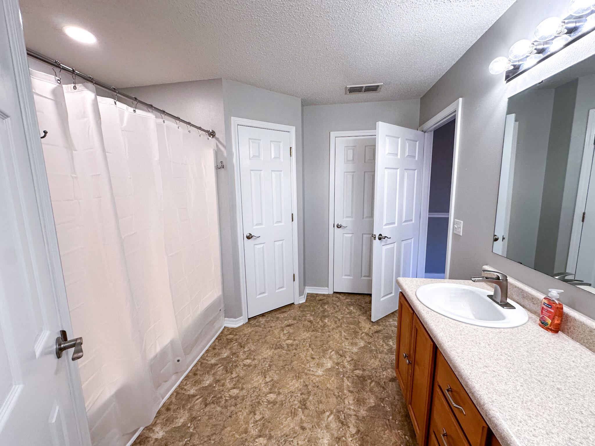 269 Limestone Circle Crestview, FL 32539 - Photo 18 of 32 a bathroom with a granite countertop sink a mirror a vanity and a shower