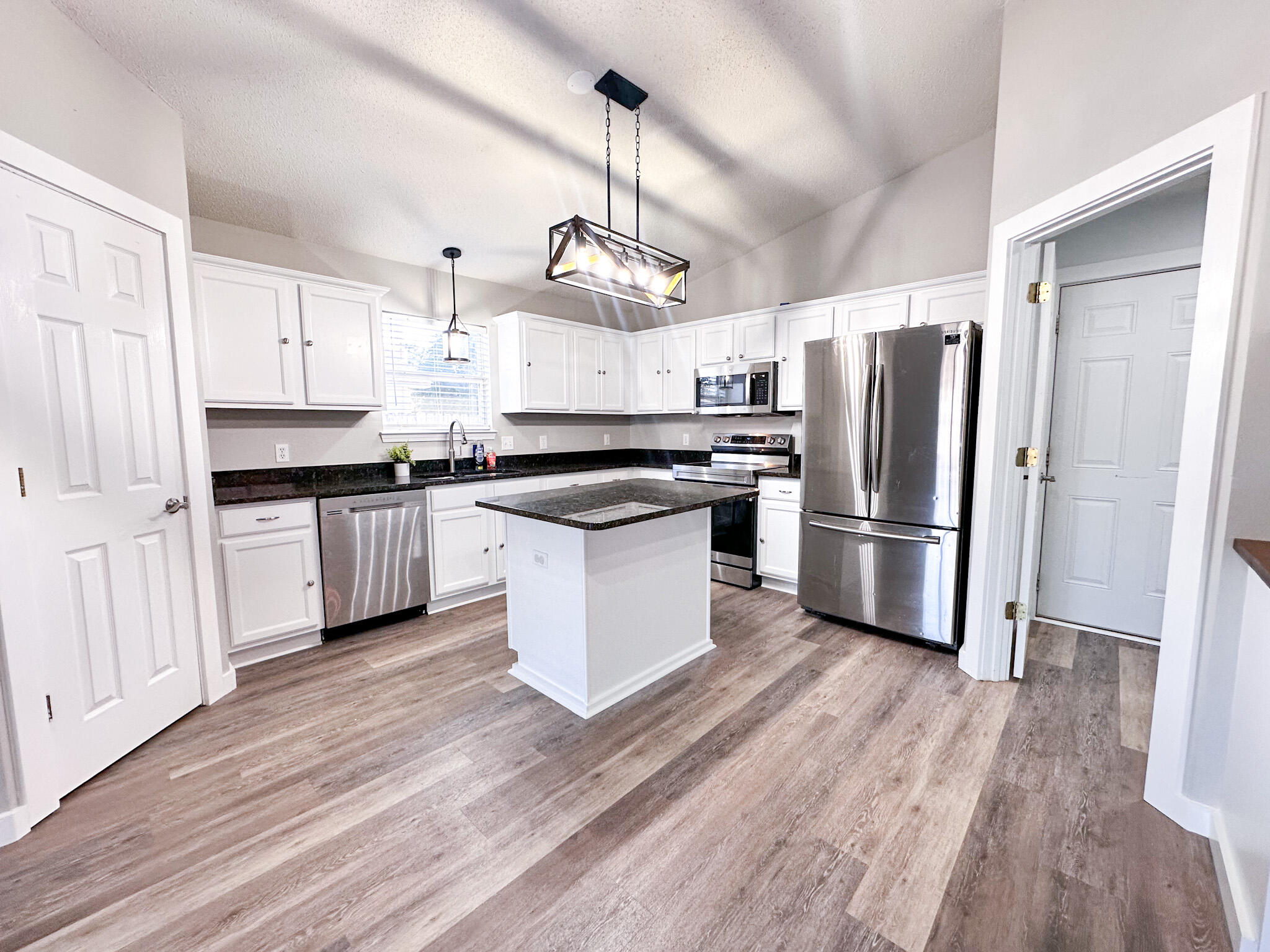269 Limestone Circle Crestview, FL 32539 - Photo 8 of 32 a kitchen with granite countertop a refrigerator and wooden floor