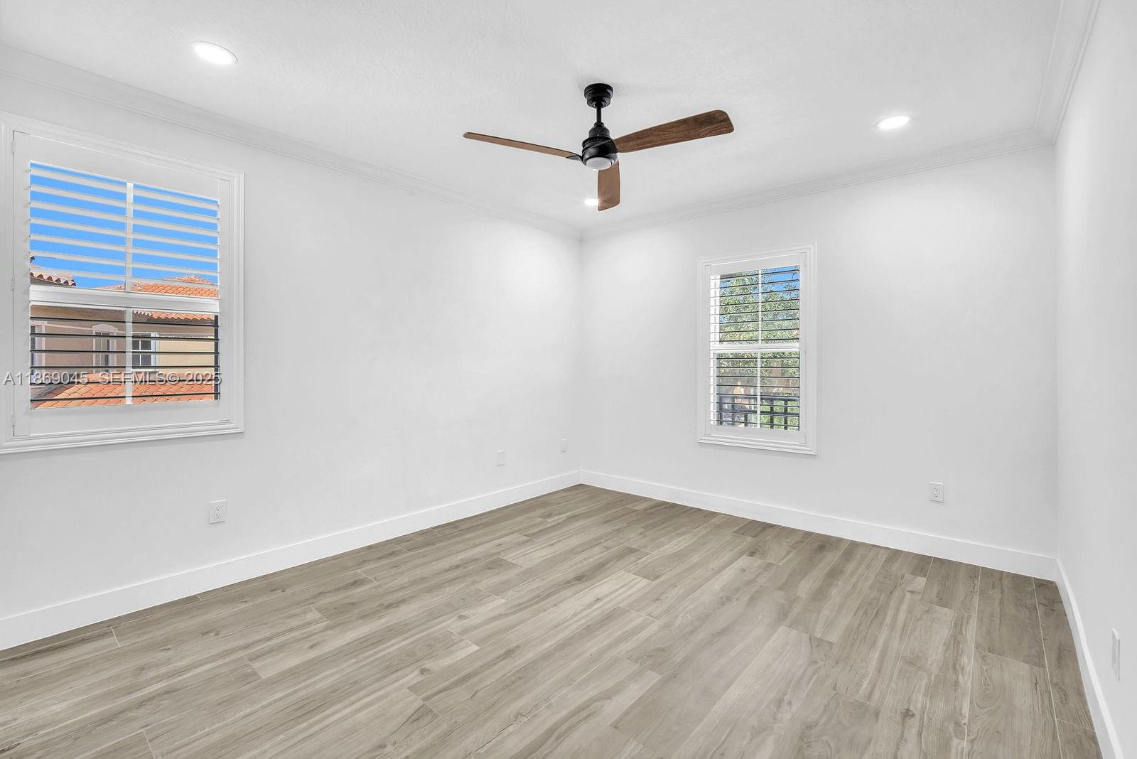 15244 Southwest 29th Terrace Miami, FL 33185 - Photo 45 of 74 an empty room with wooden floor ceiling fan and windows