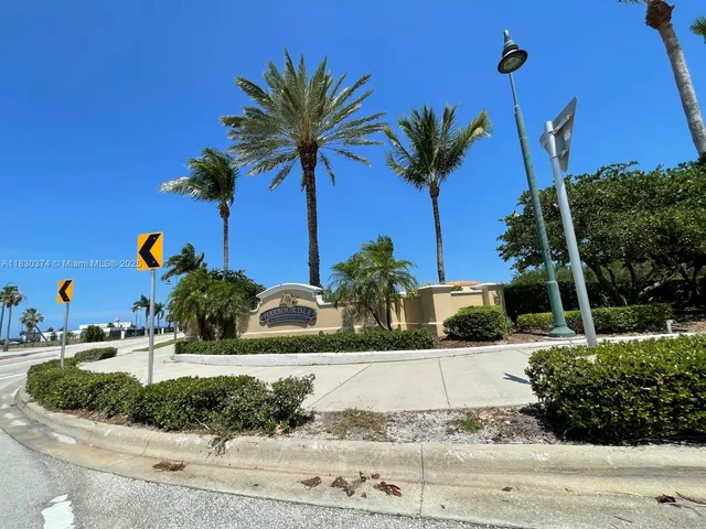 a view of a house with a yard and palm trees