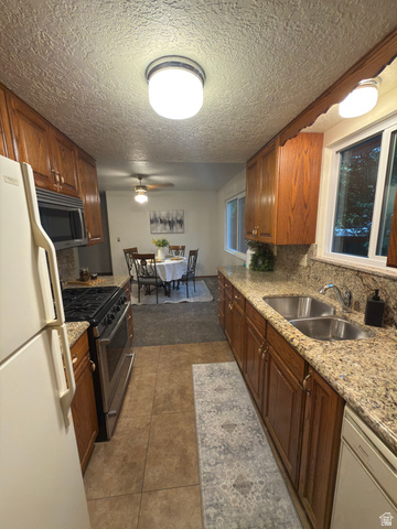 1164 East Mountain Road Logan, UT 84321 - Photo 38 of 45 Galley kitchen featuring wood cabinetry, granite-style countertops, and a dual basin stainless steel sink