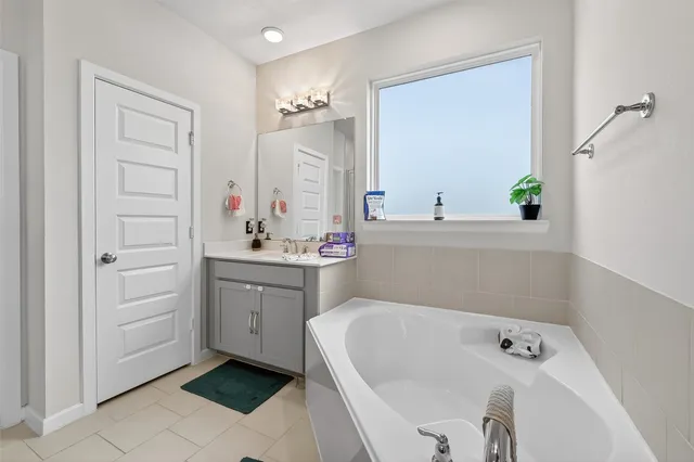 a bathroom with a tub sink and mirror