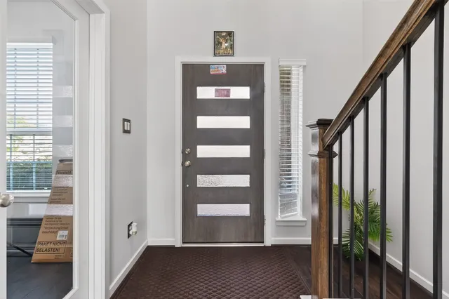 a view of a hallway with wooden floor and windows