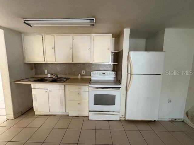 1672 10th Street Sarasota, FL 34236 - Photo 3 of 24 a kitchen with white cabinets and white appliances