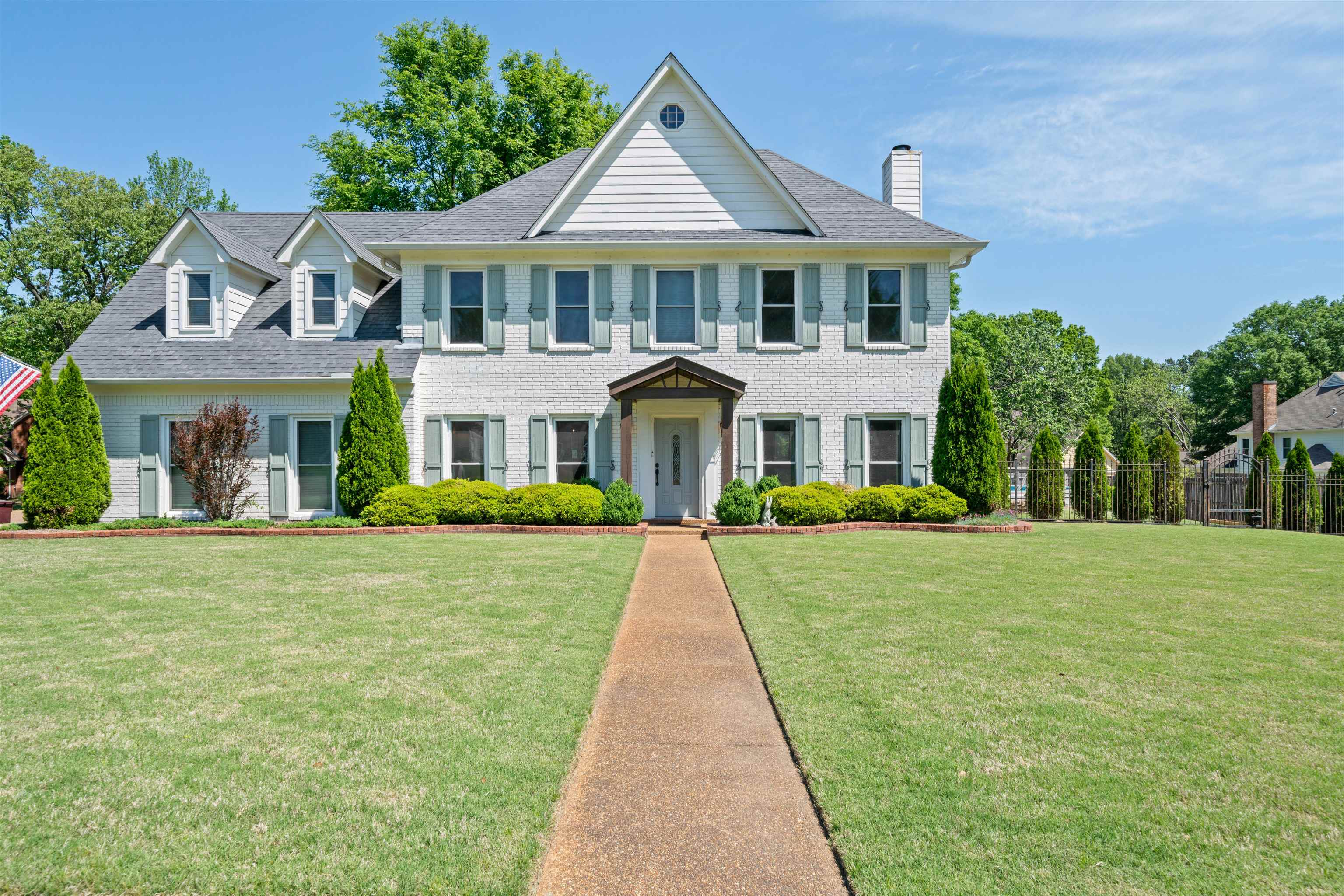 a front view of a house with yard and green space