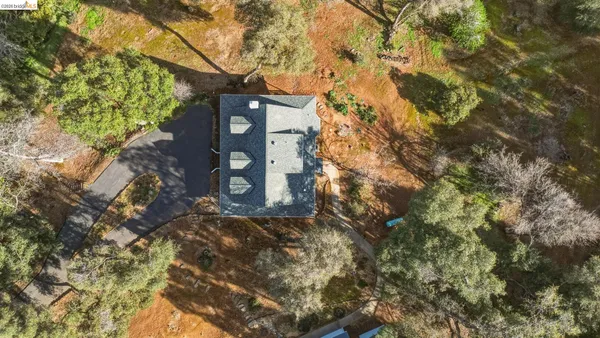 a backyard of a house with table and chairs and wooden fence